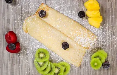 Crepe with fresh fruits and icing sugar